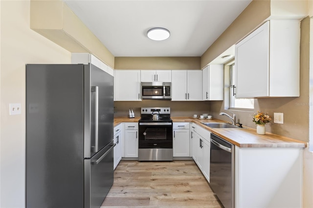 kitchen with a sink, appliances with stainless steel finishes, and white cabinets