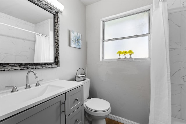 bathroom with curtained shower, toilet, and vanity