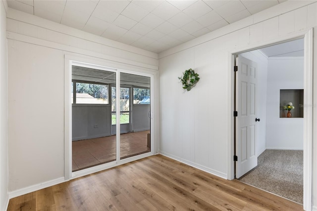 spare room featuring baseboards and light wood-type flooring