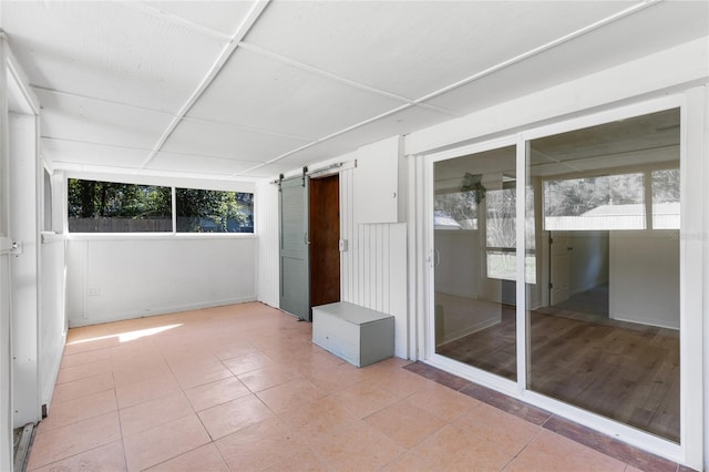 unfurnished sunroom featuring a barn door