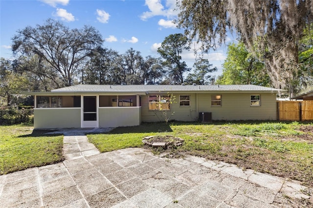 back of house with central air condition unit, a lawn, a sunroom, and fence