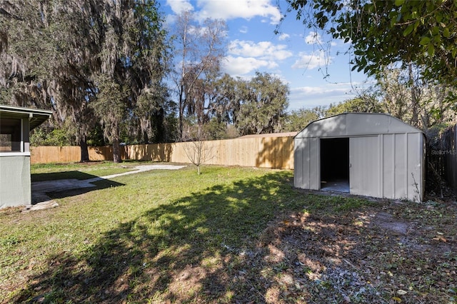 view of yard with a storage unit, a fenced backyard, and an outdoor structure