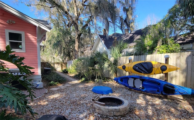 view of yard featuring an outdoor fire pit and fence