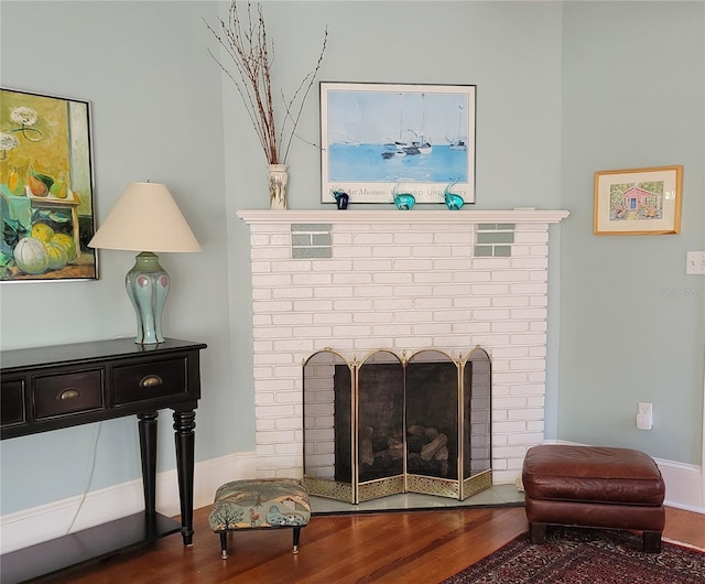 interior space with baseboards, a fireplace, and wood finished floors