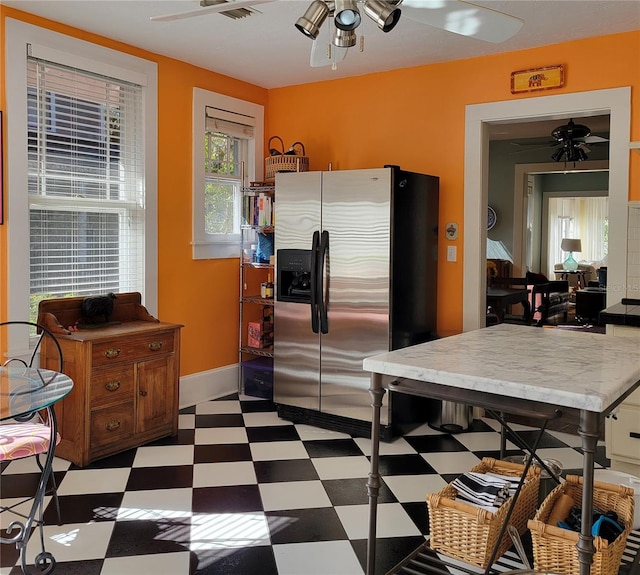 kitchen featuring tile patterned floors, a ceiling fan, baseboards, and stainless steel refrigerator with ice dispenser