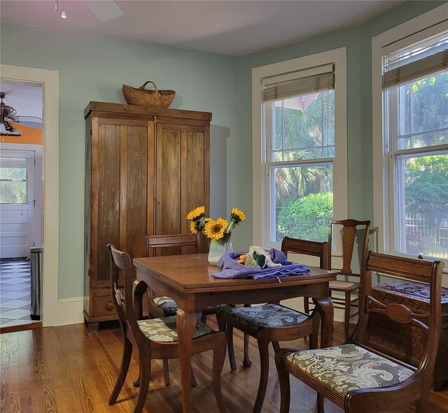 dining room with baseboards, wood finished floors, and a ceiling fan