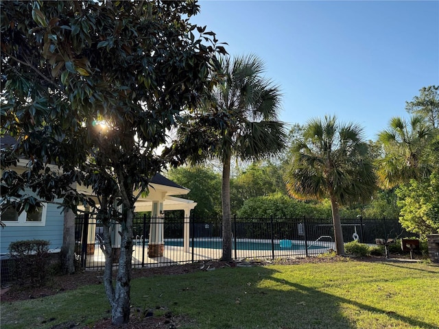 community pool with a yard and fence