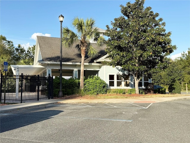 view of property featuring fence and uncovered parking