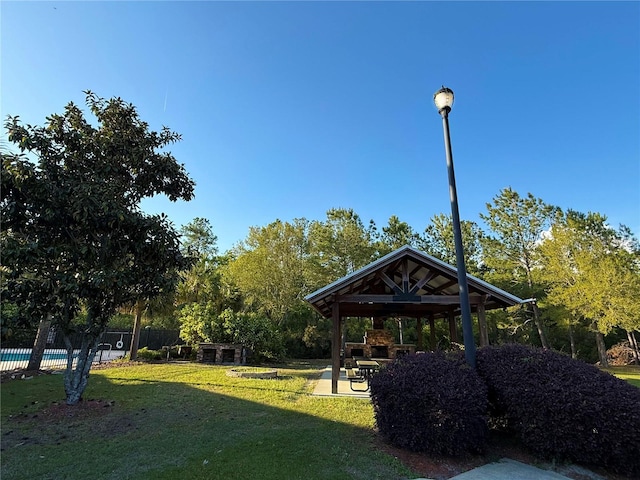 surrounding community with a patio area, a gazebo, fence, and a lawn