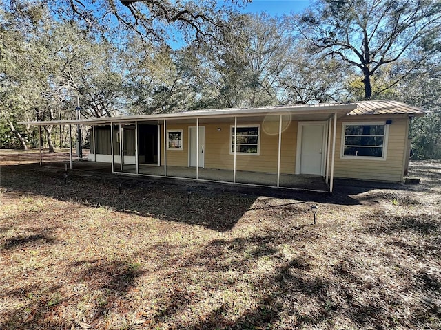 rear view of house with an attached carport and a sunroom