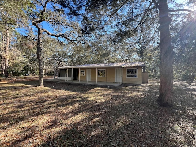 view of front of property featuring metal roof and a patio