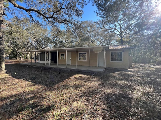 rear view of house with metal roof and a patio