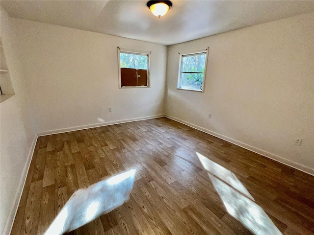 spare room featuring wood finished floors and baseboards