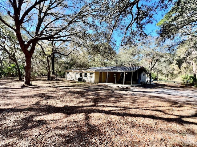 exterior space featuring metal roof and dirt driveway