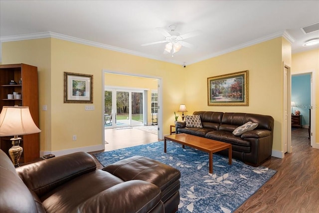 living area featuring visible vents, baseboards, ceiling fan, ornamental molding, and wood finished floors