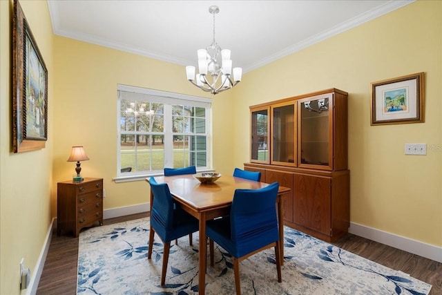 dining area with baseboards, wood finished floors, a chandelier, and crown molding