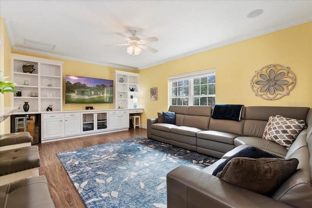 living area with ceiling fan, wood finished floors, beverage cooler, and crown molding