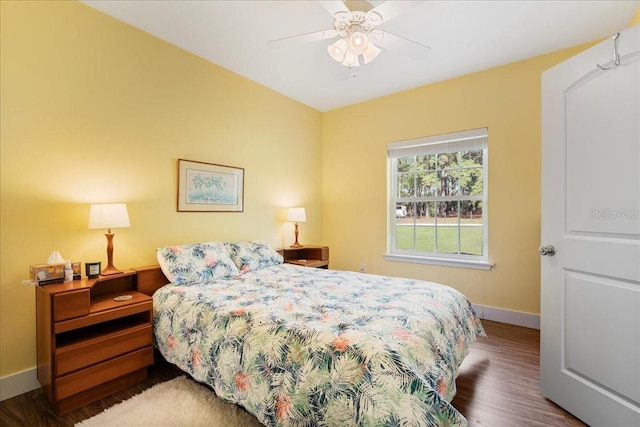 bedroom featuring a ceiling fan, wood finished floors, and baseboards