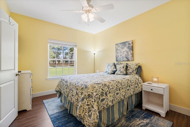 bedroom featuring a ceiling fan, baseboards, and dark wood-style flooring