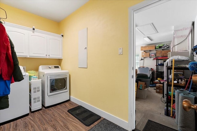 laundry area with wood finished floors, baseboards, attic access, cabinet space, and independent washer and dryer