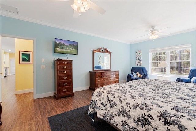 bedroom featuring ceiling fan, baseboards, wood finished floors, and crown molding