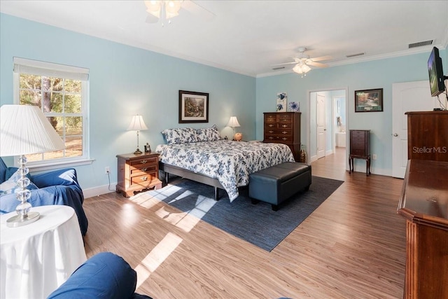 bedroom featuring visible vents, ornamental molding, baseboards, and wood finished floors