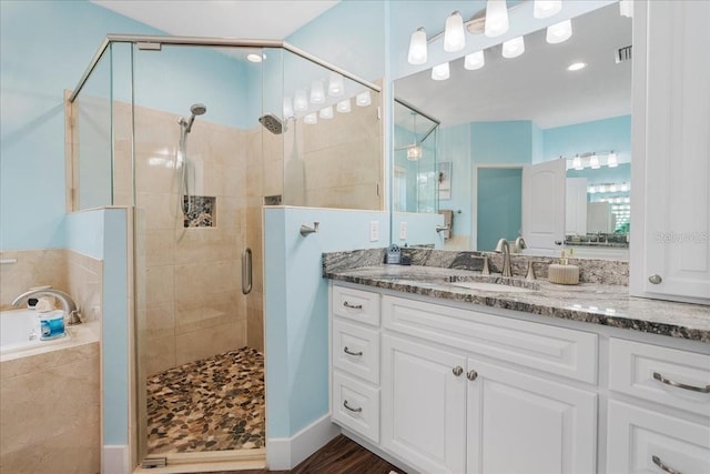 bathroom with vanity, a bath, visible vents, and a stall shower