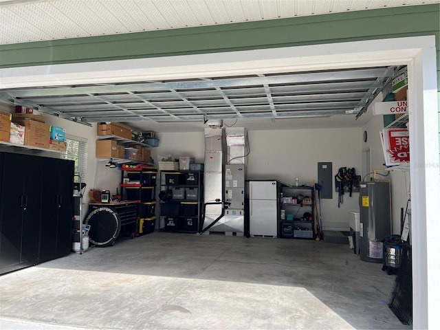 garage featuring electric panel, water heater, and freestanding refrigerator