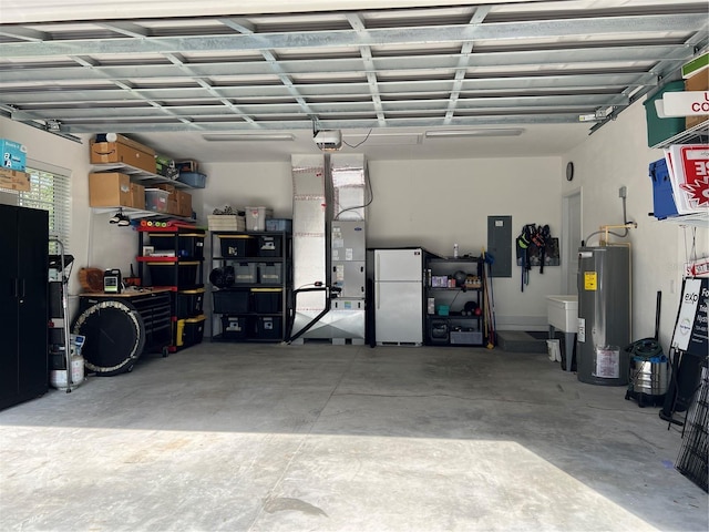 garage featuring electric panel, a garage door opener, water heater, and freestanding refrigerator