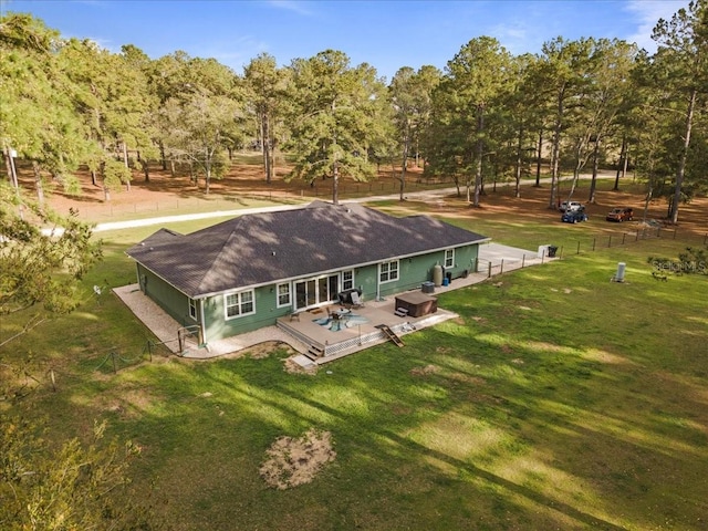 back of house with a yard, fence, roof with shingles, and a wooden deck