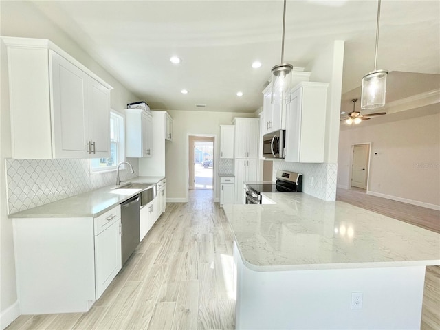 kitchen featuring tasteful backsplash, stainless steel appliances, light wood-style floors, and a sink