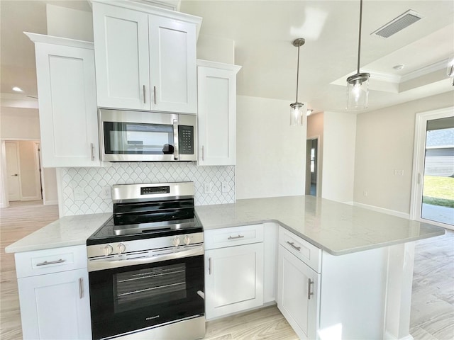 kitchen with visible vents, light stone counters, a peninsula, stainless steel appliances, and white cabinetry