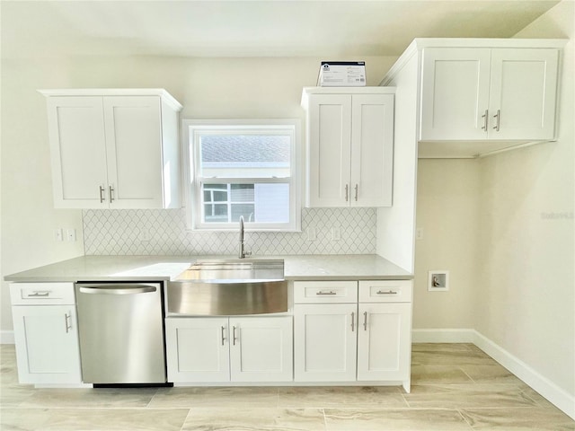 kitchen with backsplash, dishwasher, light countertops, white cabinetry, and a sink