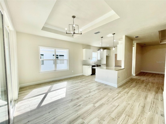 kitchen featuring white cabinets, black dishwasher, a raised ceiling, open floor plan, and a chandelier