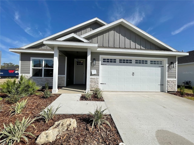 craftsman inspired home featuring driveway, a garage, board and batten siding, and stone siding