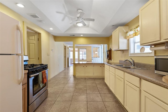 kitchen featuring visible vents, a sink, a tray ceiling, appliances with stainless steel finishes, and ceiling fan