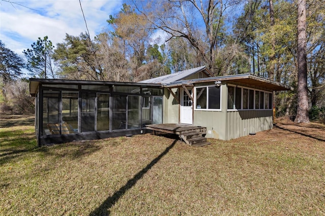 view of front of home with a front yard, a sunroom, and metal roof