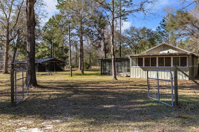 view of yard with a detached carport and a sunroom