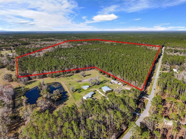 drone / aerial view featuring a view of trees and a water view