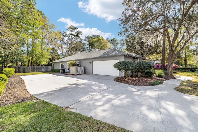 view of home's exterior featuring stucco siding, an attached garage, driveway, and fence