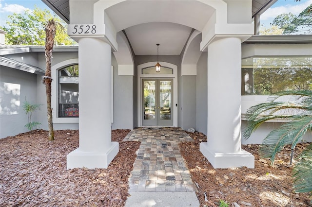 property entrance featuring stucco siding and french doors