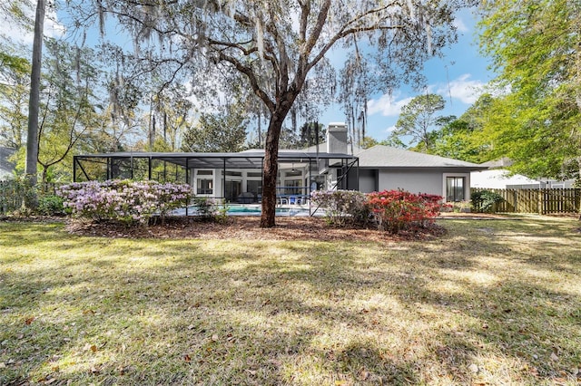 back of house featuring a fenced in pool, fence, glass enclosure, a chimney, and a yard