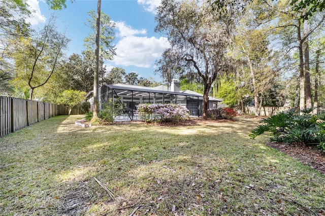 view of yard featuring glass enclosure and a fenced backyard