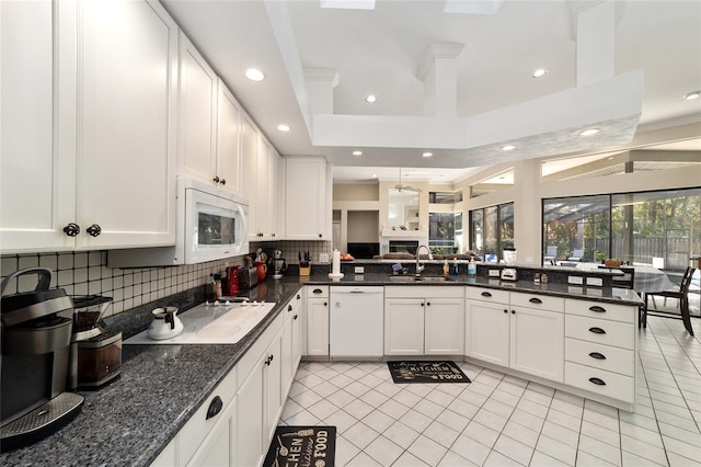 kitchen featuring a sink, white appliances, tasteful backsplash, and white cabinets