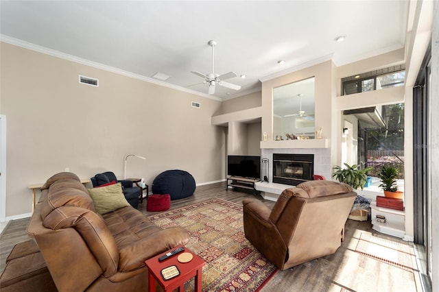 living room featuring visible vents, ornamental molding, ceiling fan, and wood finished floors