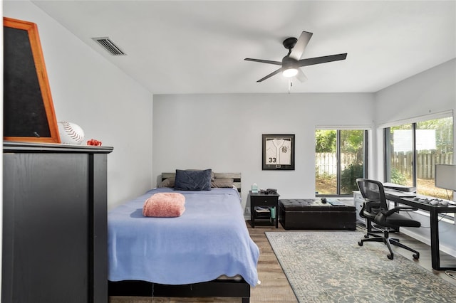 bedroom featuring a ceiling fan, wood finished floors, and visible vents