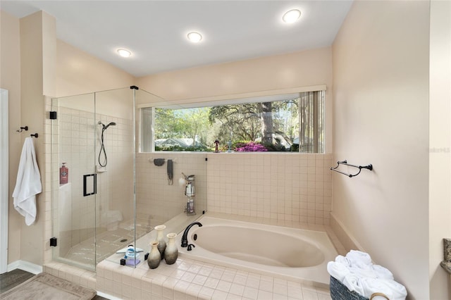 bathroom featuring a wealth of natural light, a bath, and a shower stall