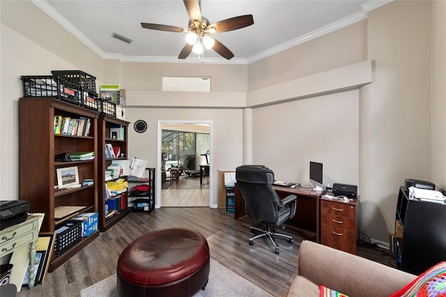 office space featuring dark wood finished floors, crown molding, visible vents, and ceiling fan