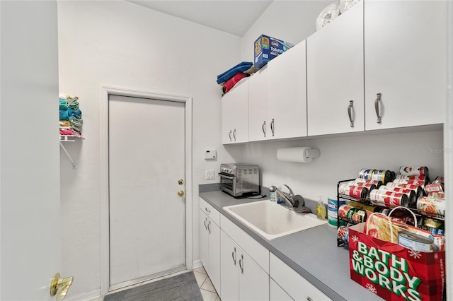 kitchen featuring white cabinetry and a sink