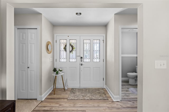 entryway with light wood-type flooring and baseboards